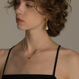 Elegant And Versatile Gold Bean Ingot Classic Necklace worn by a model with curly hair.