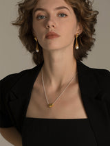 Elegant And Versatile Gold Bean Ingot Classic Necklace worn by a model with earrings, showcasing elegant fashion style.